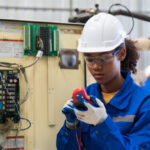 Female electrician worker checking, repair, maintenance operation electric system in the factory. Woman electrician engineer working with operation electric system at production line